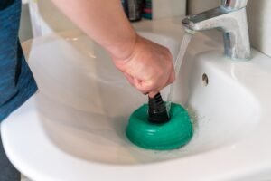 A Rhino Rooter plumber works to clear a clogged bathroom sink in The Wasatch Front.